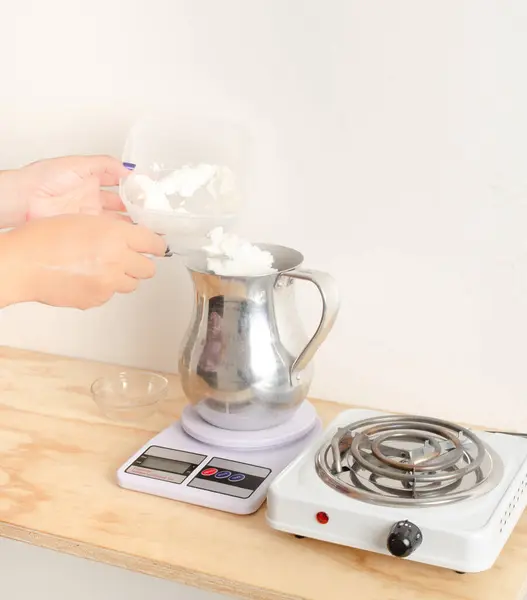 stock image Woman weighing soy vegetable wax for biodegradable candles, vegetable waxes, organic. Small businesses, female businesses.