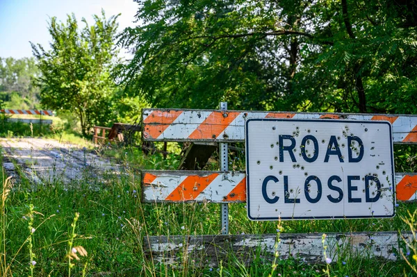 Buckshot road closed sign in front of a washed out bridge. High quality photo