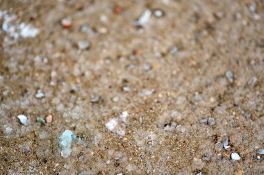 Buz tabakası ile beton üzerinde erimiş kaya tuzu yüzeyinin makro seviye yakın çekim görüntüsü. Yüksek kalite fotoğraf