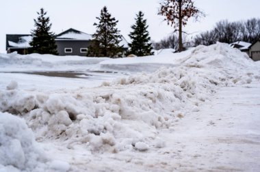 Kar küreme aracı bir caddeyi temizledikten sonra yola çıkan kar yığını. Yüksek kalite fotoğraf