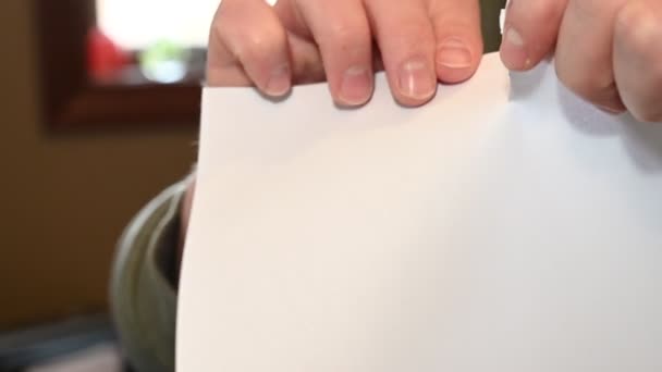 Δύο Λευκά Χέρια Σχίζουν Ένα Λευκό Φύλλο Χαρτιού Στη Μέση — Αρχείο Βίντεο