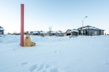 Fire hydrant protruding from a snow back along a residential street. . High quality photo