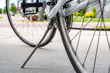 Metal tekme standı beton zeminde park etmiş bir bisikleti desteklemek için genişletildi.