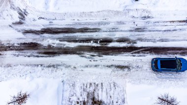 Aerial drone overhead view of a city street and plowed in residential driveway. High quality photo