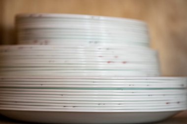 Seramik tabaklar ve kaseler istiflenmiş açık mutfak dolabının alan derinliği yüksek kaliteli fotoğraf.