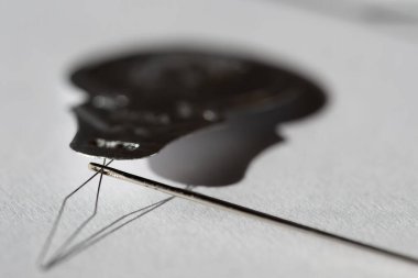 Kullanımda olan iğne ipliği aleti ve tek bir siyah ip. - Evet. Yüksek kalite fotoğraf