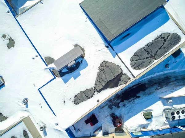 stock image Elevated overhead drone view of a flat roofed building with snow load and ventilation units. High quality photo