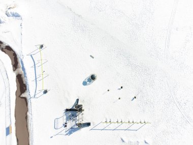 Aerial overhead drone view of school playground equipment covered in snow. High quality photo
