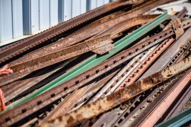 Pile of rusted steel fence posts on the ground. High quality photo