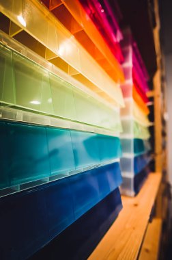 Rows of multi-colored storage bin totes in a retail store shelving space. High quality photo clipart