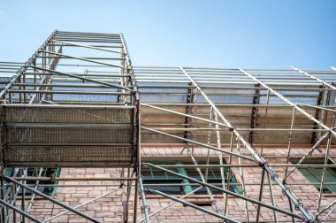 Eski bir binanın dışında gökyüzüne bakan iskeleler inşa edilmişti. Yüksek kalite fotoğraf