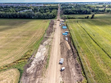 Tarlaların tarım bölgesini kesen bir yol yapım projesinin yüksek açılı görüntüsü. Yüksek kalite fotoğraf