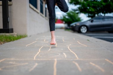 Çıplak ayakla sek-scotch oynayan bir kızla tebeşir numaralarına odaklan. Yüksek kalite fotoğraf