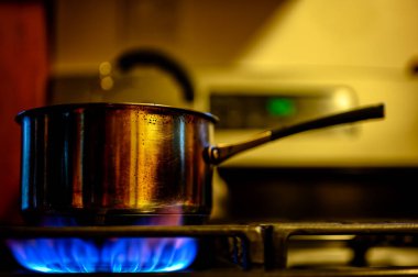 Kabin mutfağında doğal gaz ocağı metal bir tencereyi ısıtıyor. Yüksek kalite fotoğraf