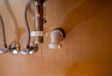 Banyodaki lavabo giderine odaklanmak ve saç tıkaçlarını sökmek. Yüksek kalite fotoğraf