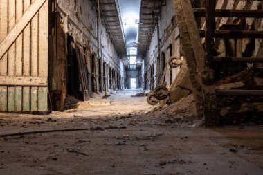 Ground level view of the dirty floor down a cell block at Eastern State Penitentiary historic site. High quality photo clipart