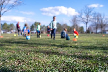 Arka planda bulanık çocuklar futbol antrenmanı olan çimenlere odaklan. Yüksek kalite fotoğraf