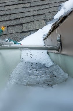 Ice and snow building up inside a rooftop gutter system on a residential house. High quality photo clipart