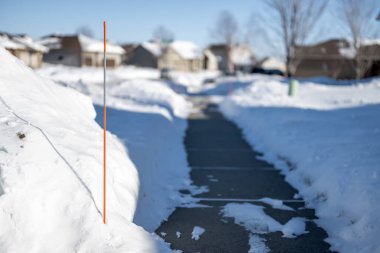 Sidewalk with edge markers used for snow blowing guides. High quality photo clipart