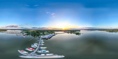 Güneş uzaklardan batarken rıhtımdaki teknelerin insansız hava aracı görüntüsü bozuluyor. Yüksek kalite fotoğraf