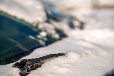 ice and snow covered front windshield wiper blades on a vehicle. High quality photo