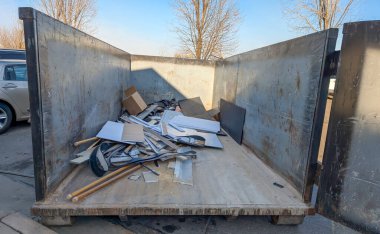 İnşaat atıklarıyla dolu açık bir çöp konteynırının içine bak. - Evet. Yüksek kalite fotoğraf