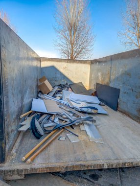 İnşaat atıklarıyla dolu açık bir çöp konteynırının içine bak. - Evet. Yüksek kalite fotoğraf