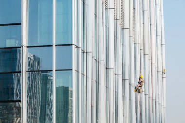 Chengdu, Sichuan Eyaleti, Çin - 21 Aralık 2022: Güneşli bir günde gökdelenleri temizleyen işçiler