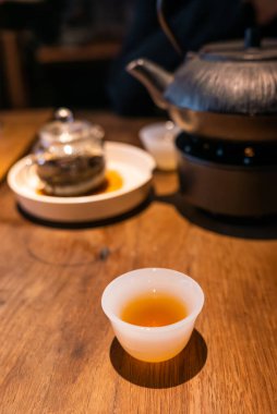 Cup of Chinese tea and teapot on a wooden table close-up view