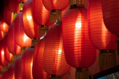 Bir dizi kırmızı Çin feneri aydınlatılarak sıcak ve şenlikli bir atmosfer yaratılıyor..