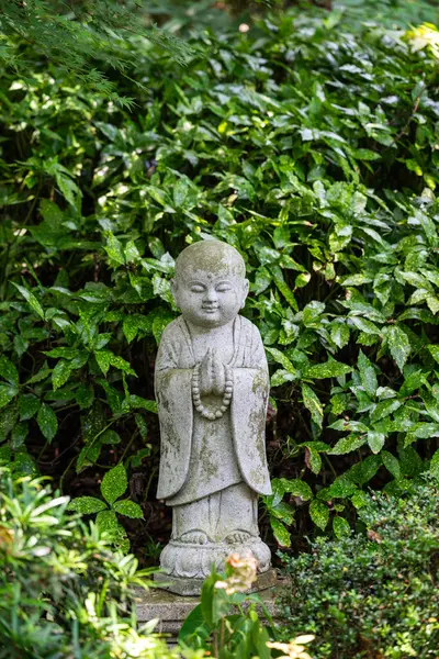 Yeşilliklerle çevrili meditasyon pozisyonunda bir Buda heykeli Çin maneviyatının sükunetini yakalıyor..