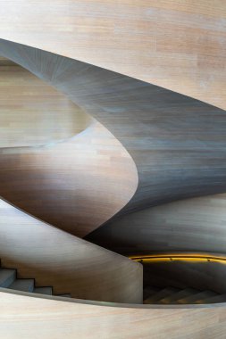 Ahşap panellerden oluşan merdiven, doğal ve modern tasarımın kusursuz bir karışımını oluşturuyor. Merdivenin eğriliği dinamik ve sıvı bir estetik eklerken ahşap paneller...