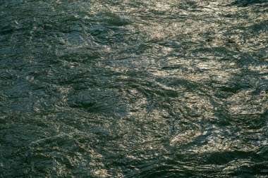 Güneş ışığı, Sichuan 'ın DuJiangYan bölgesindeki Min Nehri' nin yüzeyinde dans eder. Suyun canlı hareketini yansıtan ışıltılı bir etki yaratır. Bu doğal ortam zenginleri gösteriyor.