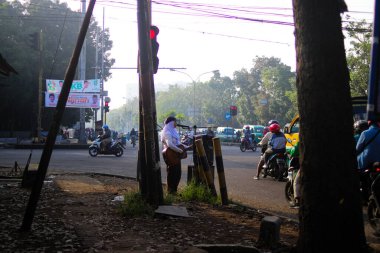 Bandung, West Java, Endonezya - 31 Temmuz 2022: Endonezyalı bir kız sabah Bandung 'da bir kavşakta gitar çalıyor.