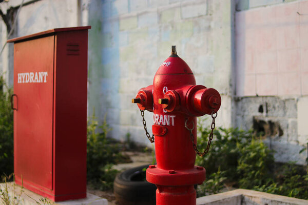 Red fire hydrant in an Indonesian gas station. Fire hydrant or water plug provide the water required by fire fighters to extinguish a fire. usually placed inside or outside a building, parking area.