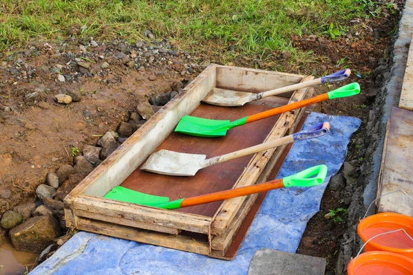 a group of shovels is laid on the ground in preparation for the symbolic laying of the foundation stone for the construction of a building.