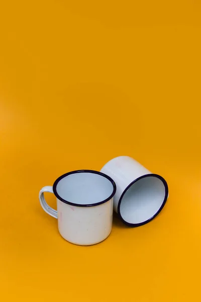 オレンジの背景に白いマグカップが2つ 白いマグカップ ステンレス製マグカップ キャンプ用マグカップ — ストック写真