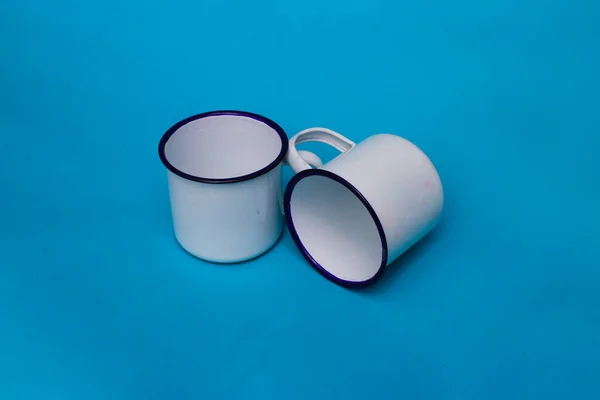 青い背景に白いマグカップが2つ 白いマグカップ ステンレス製マグカップ キャンプ用マグカップ — ストック写真
