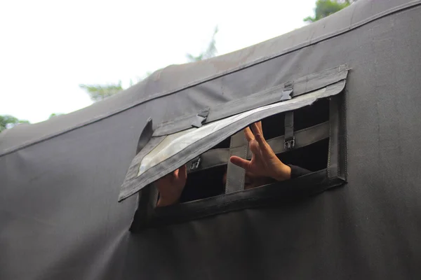 Hand try to open truck curtain on an Indonesian army truck.