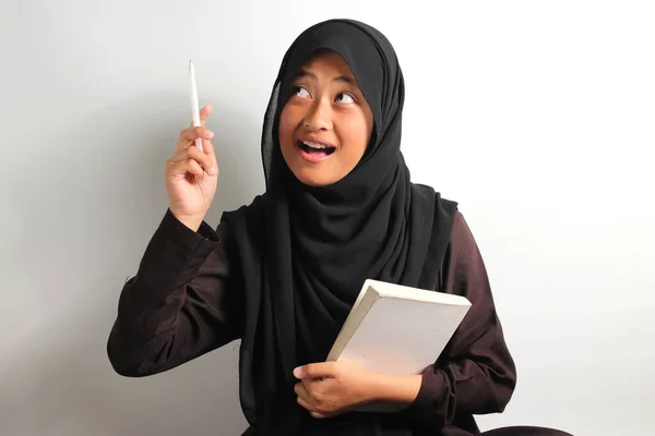 Podekscytowana Młoda Azjatka Czarnym Hidżabie Lub Chustce Trzymając Książkę Długopis — Zdjęcie stockowe