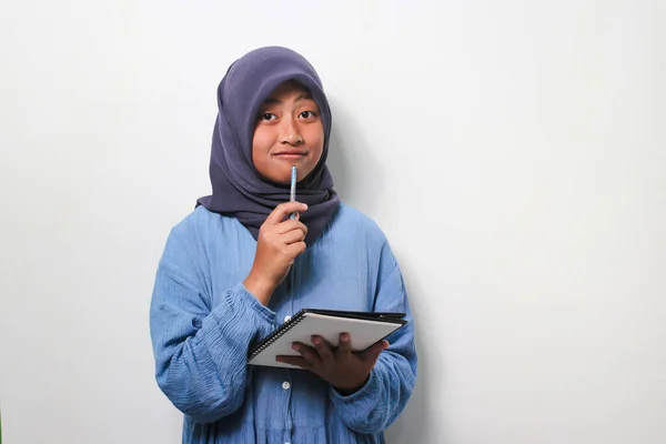 Улыбающаяся Молодая Азиатская Студентка Хиджабе Заинтересована Мышлении Держа Книгу Ручку — стоковое фото