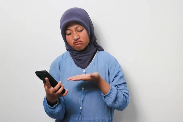 Запутавшаяся Молодая Азиатка Хиджабе Одетая Повседневную Рубашку Держит Телефон Белом — стоковое фото