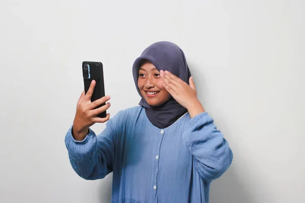 陽気若いですアジアの女の子でHihab身に着けていますでカジュアルなシャツアップ彼女の手オンビデオコールで携帯電話隔離された白い背景 — ストック写真