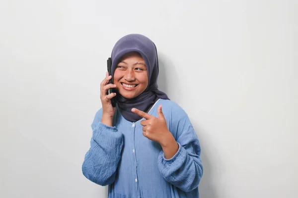 Szczęśliwa Młoda Azjatka Hidżabie Ubrana Luźną Koszulę Wykonuje Telefon Wskazując — Zdjęcie stockowe