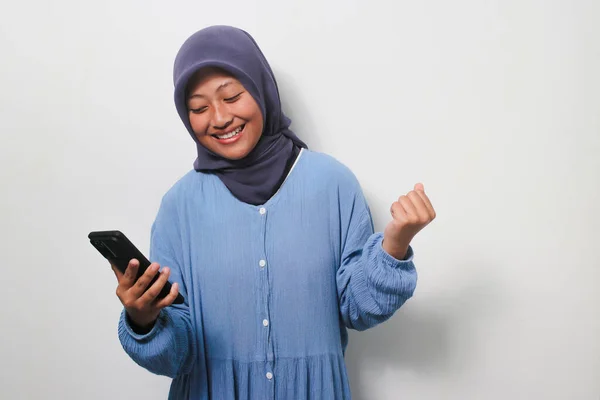 Podekscytowana Młoda Azjatka Hidżabie Ubrana Luźną Koszulę Patrząc Smartfona Otrzymując — Zdjęcie stockowe