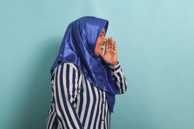 Mavi tesettürlü ve çizgili tişörtlü orta yaşlı bir Asyalı kadın mavi arka planda dikilirken bir sır fısıldıyor ve dedikoduları paylaşıyor.