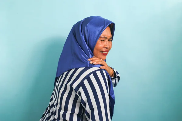 青のヒジャーブマッサージ首 肩のアジアの女性 過労から筋肉痛を軽減 誤った姿勢 青の背景を背景に — ストック写真