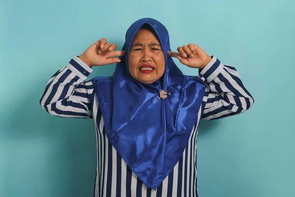 Irytująca Azjatka Średnim Wieku Niebieskim Hidżabie Trzyma Uszy Dłońmi Odczuwając — Zdjęcie stockowe