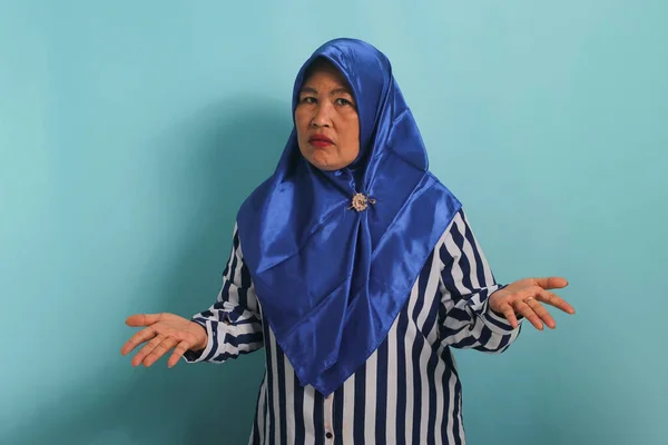Zakłopotana Azjatka Średnim Wieku Niebieskim Hidżabie Koszuli Paski Rozkładająca Ręce — Zdjęcie stockowe