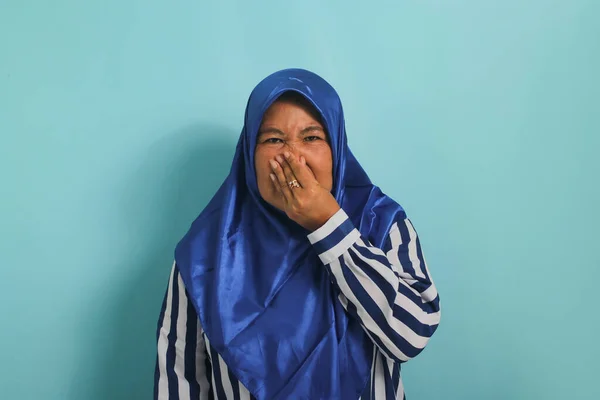 Azjatka Średnim Wieku Niebieskim Hidżabie Wstrzymuje Oddech Szczypie Się Nos — Zdjęcie stockowe